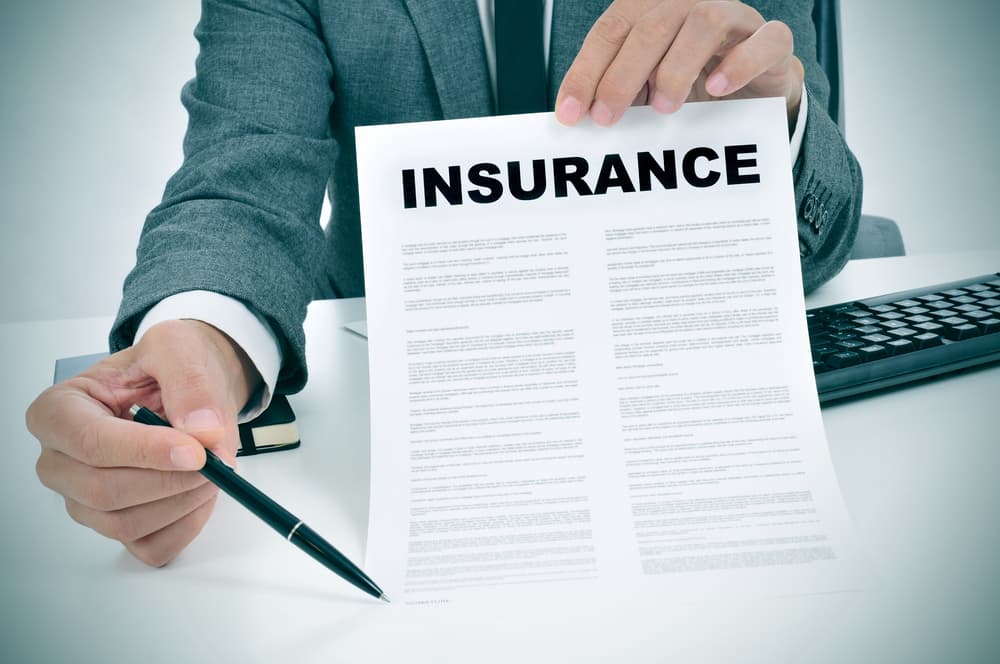 Man holding up insurance paper
