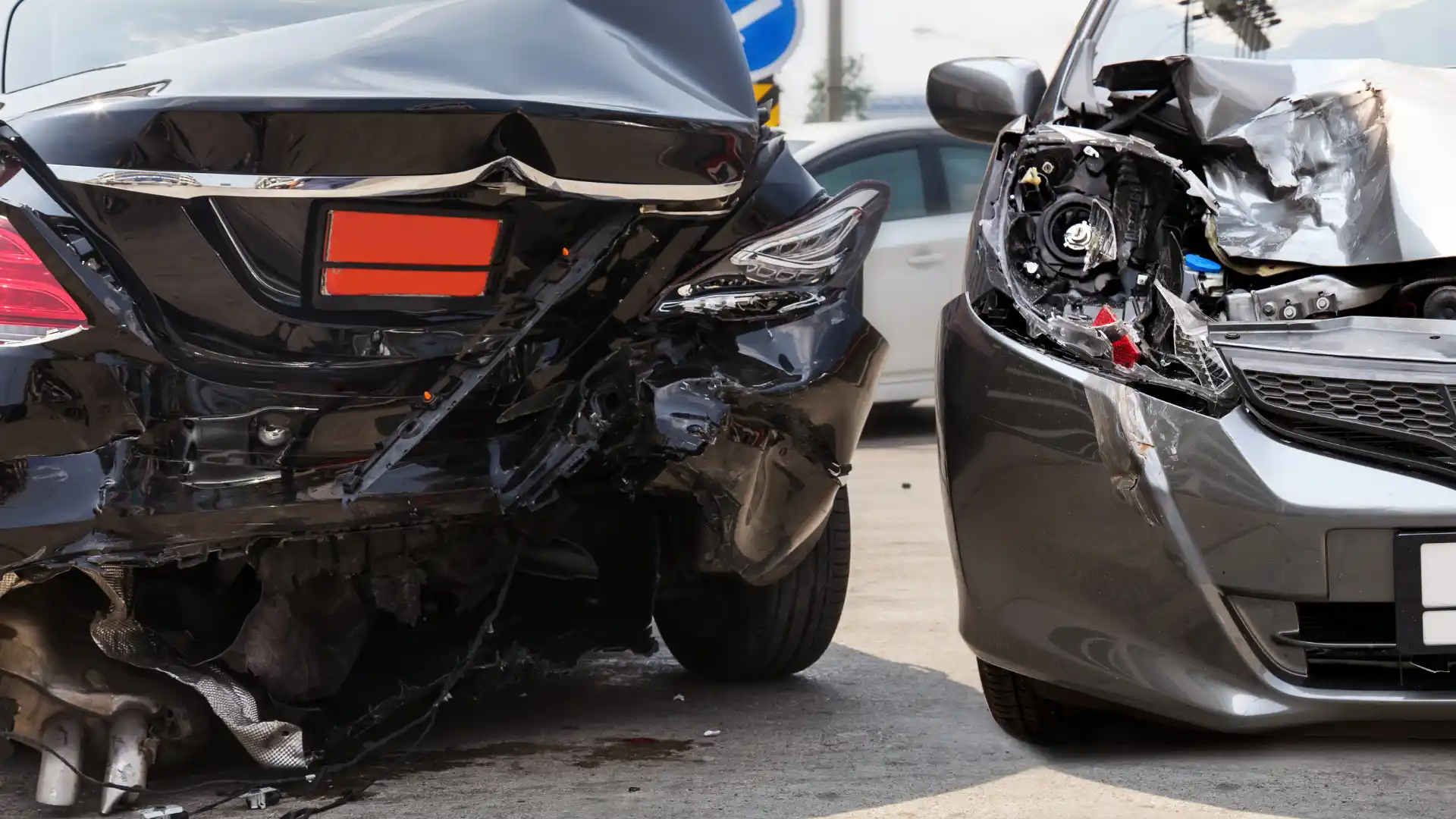 Two cars with severe rear-end collision damage.