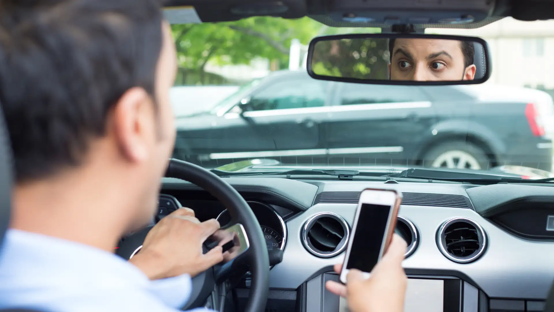 A driver using a phone while driving, distracted in a vehicle.